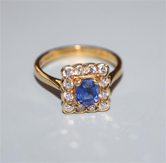 A modern 18ct gold, cushion emerald cut sapphire and diamond set square cluster ring, size M.
